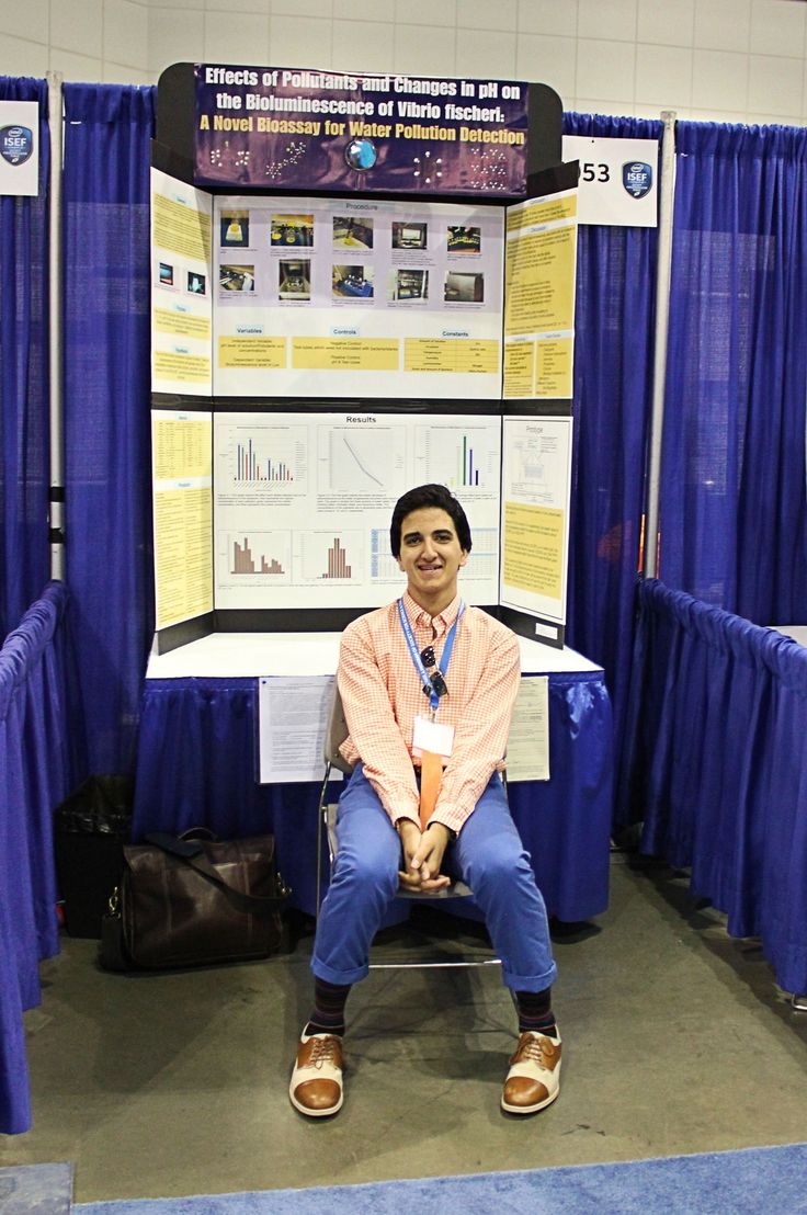 a man sitting on a chair in front of a poster