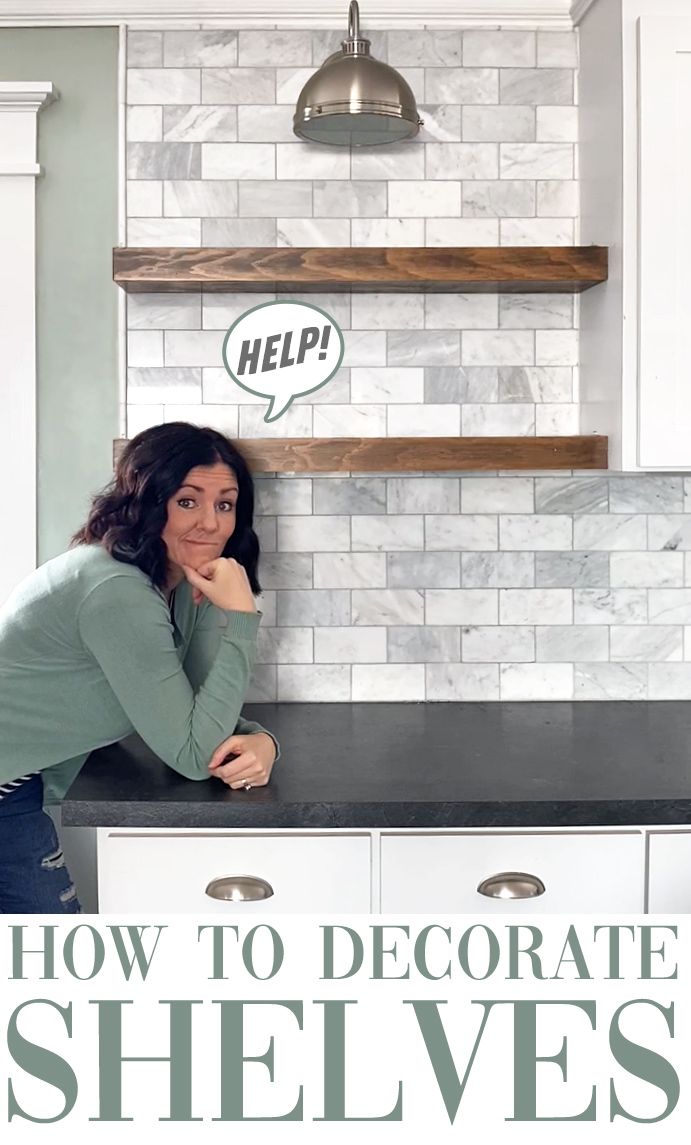 a woman leaning on the counter in front of a shelf with shelves above her head