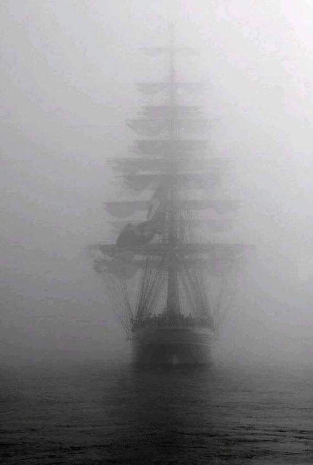 a tall ship sailing in the foggy ocean