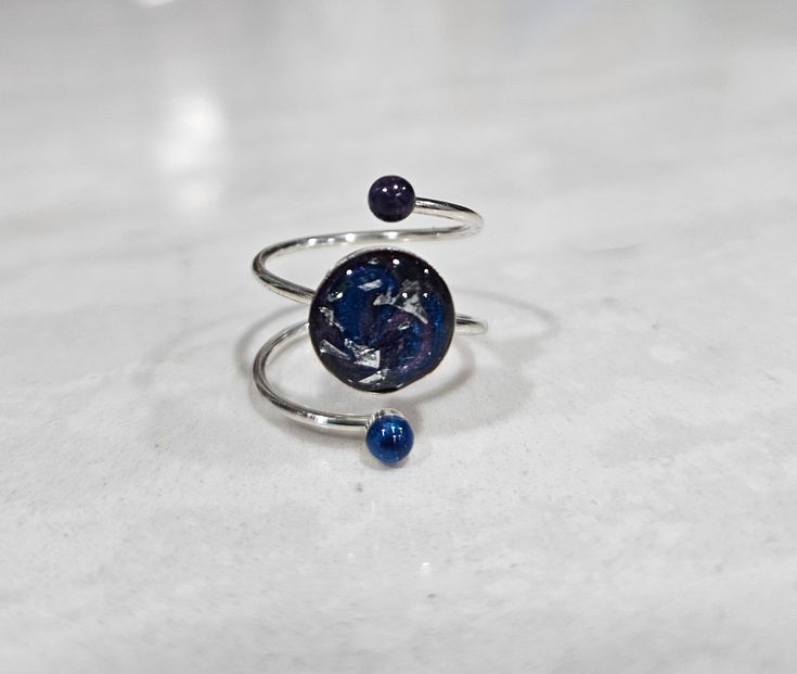 1 galaxy inspired ring, adjustable size. 925 Sterling Silver ring with blue and purple resin design with silver accents. Would make a great accessory or gift. Celestial Style Blue Ring As Gift, Celestial Style Blue Ring As A Gift, Celestial Blue Ring As A Gift, Celestial Blue Ring As Gift, Handmade Blue Celestial Rings, Handmade Celestial Blue Rings, Space Ring, Space Rings, Purple Resin