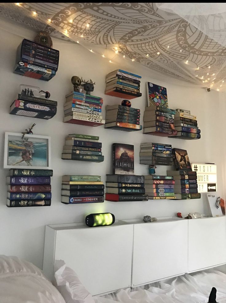 there are many books on the wall above the bed