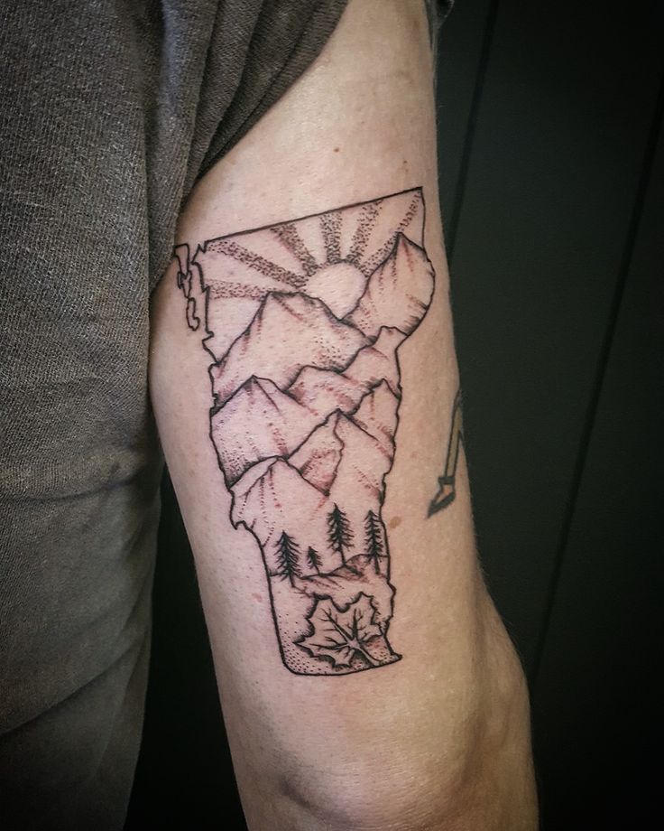 a person with a tattoo on their arm that has trees in the shape of a map