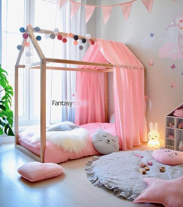 a child's bedroom with pink bedding and accessories on the floor, including stuffed animals