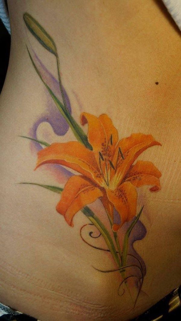 a woman's stomach with an orange flower tattoo on her belly and the bottom part of her lower back