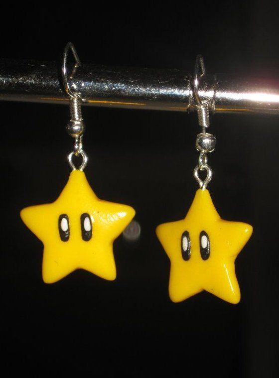 two yellow star shaped earrings hanging from a hook