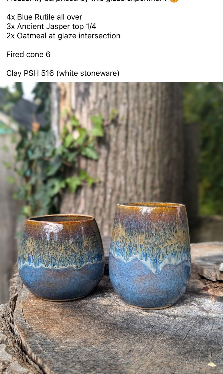 two blue cups sitting on top of a wooden table next to a green tree trunk