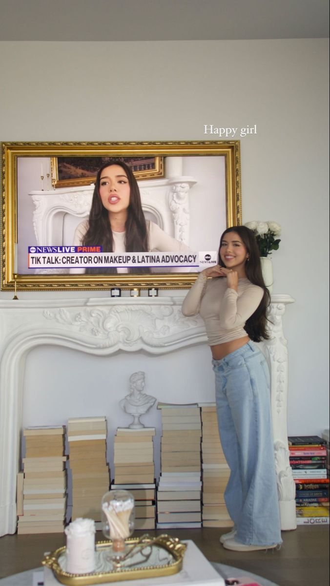 a woman is standing in front of a television screen with an ad on the wall behind her