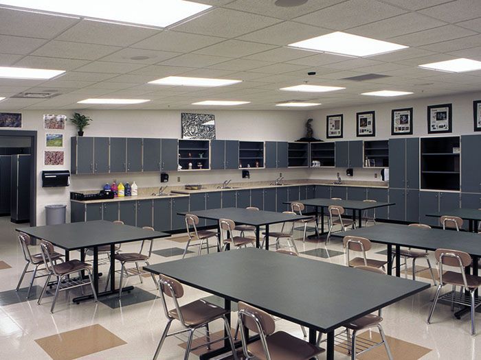 an empty classroom with desks and chairs in the middle of it, all lined up against the wall