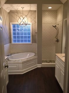 a bathroom with a large tub and wooden floors