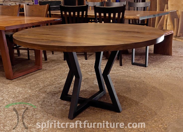 a wooden table with black metal legs in a room filled with tables and chairs,