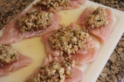 several pieces of meat on a cutting board with crumbs and seasoning sprinkles