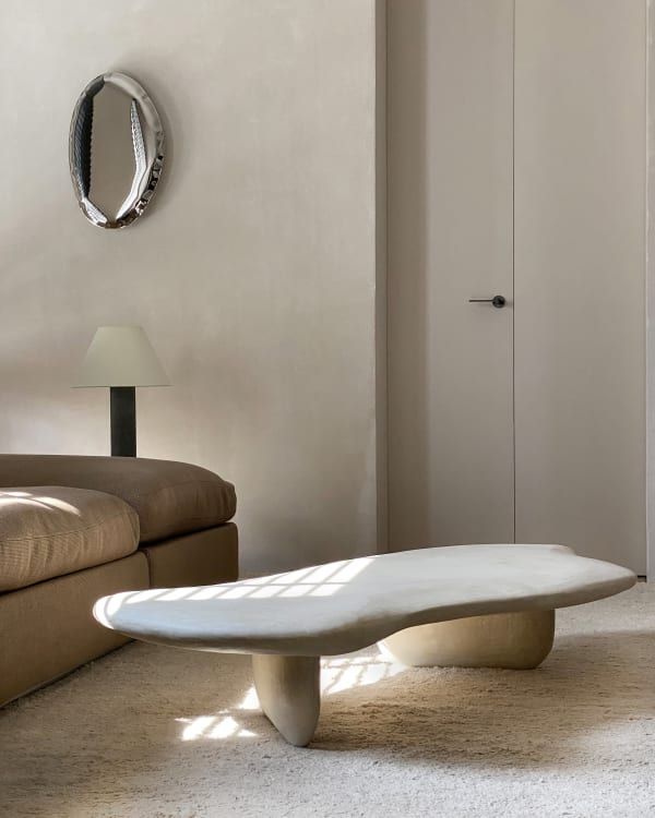 a white surfboard sitting on top of a living room floor next to a couch