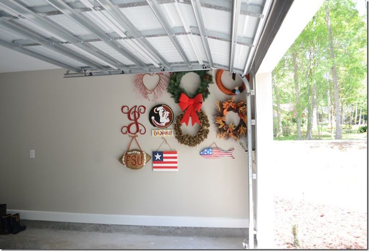 a garage with several wreaths hanging on the wall and american flag decorations above it