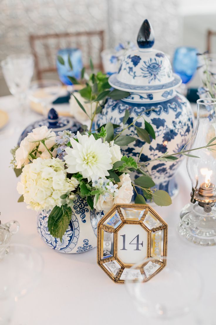 a table topped with blue and white vases filled with flowers