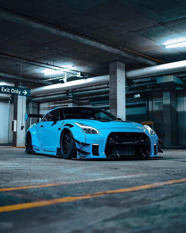 a blue sports car is parked in an empty parking garage with no one around it