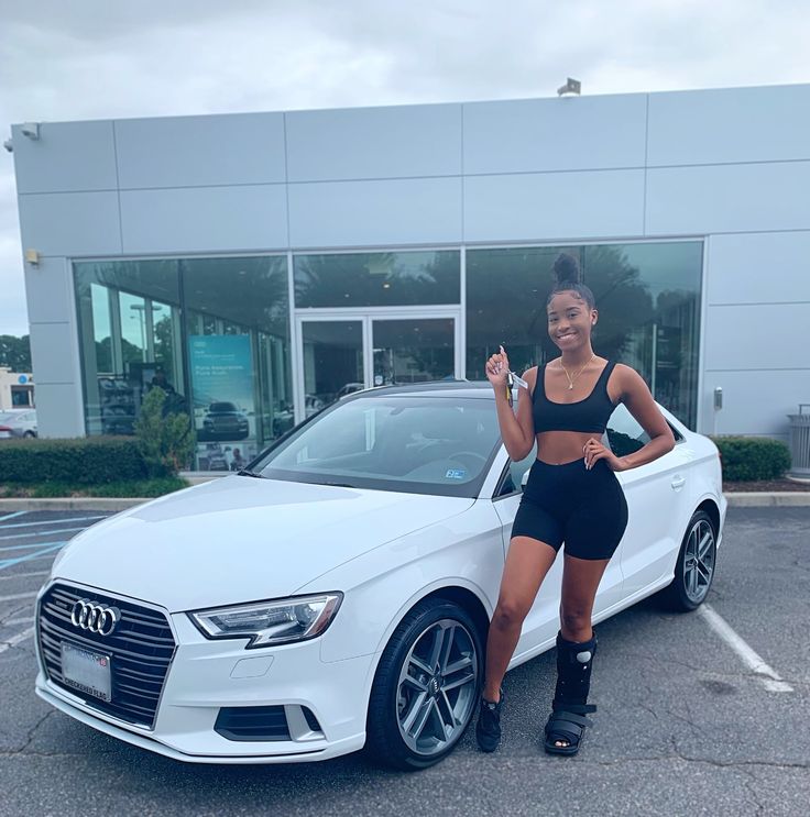 a woman standing next to a white car