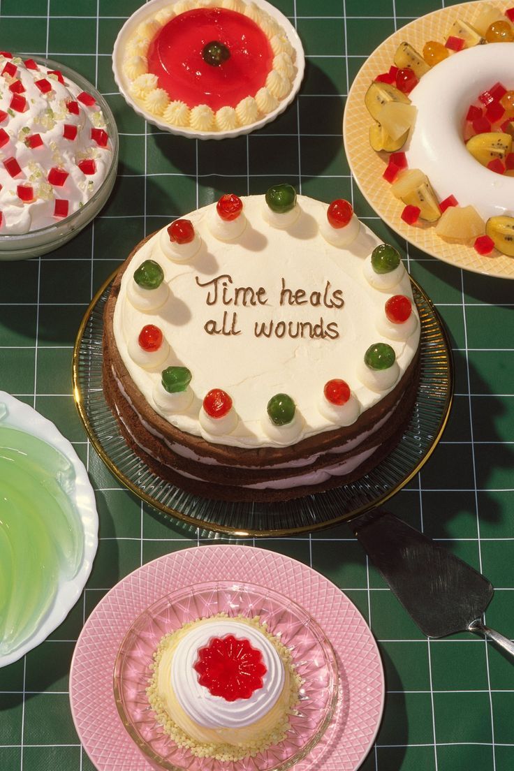 a table topped with cakes and pies covered in frosting