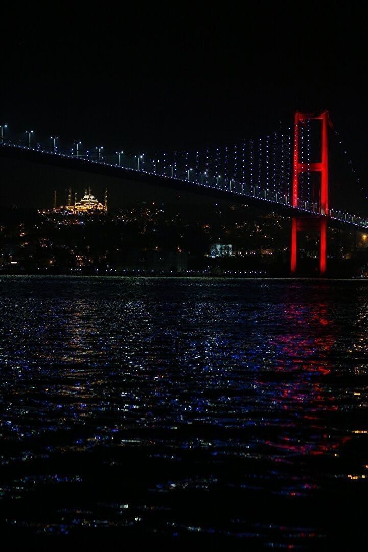 a bridge lit up at night over the water