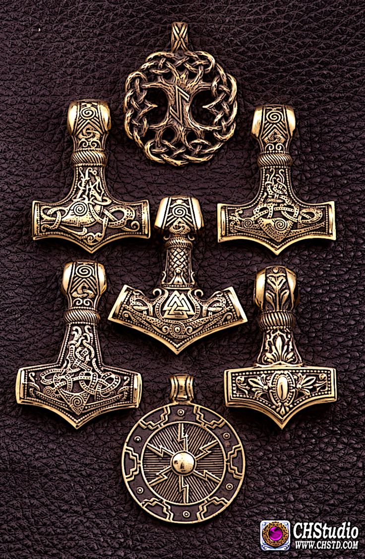 four pieces of gold colored metal with designs on them, including an iron cross and two axes