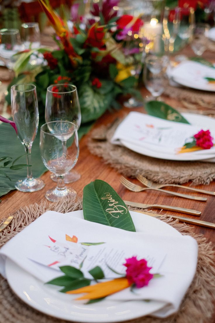 the table is set with place settings and flowers