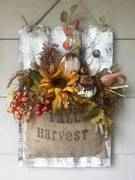 a fall harvest sign hanging on the side of a building with pumpkins, leaves and acorns