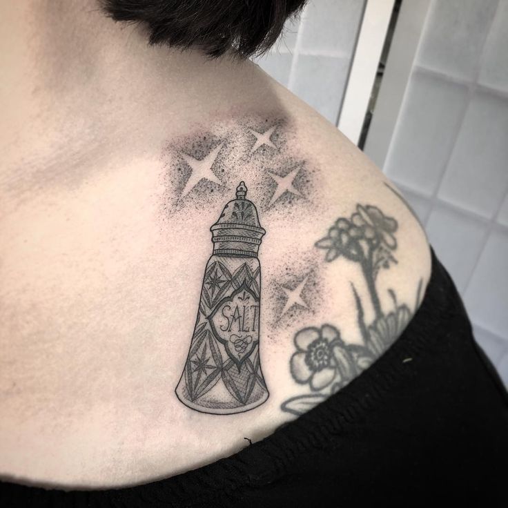 a woman with a tattoo on her chest has a small clock in the top of it