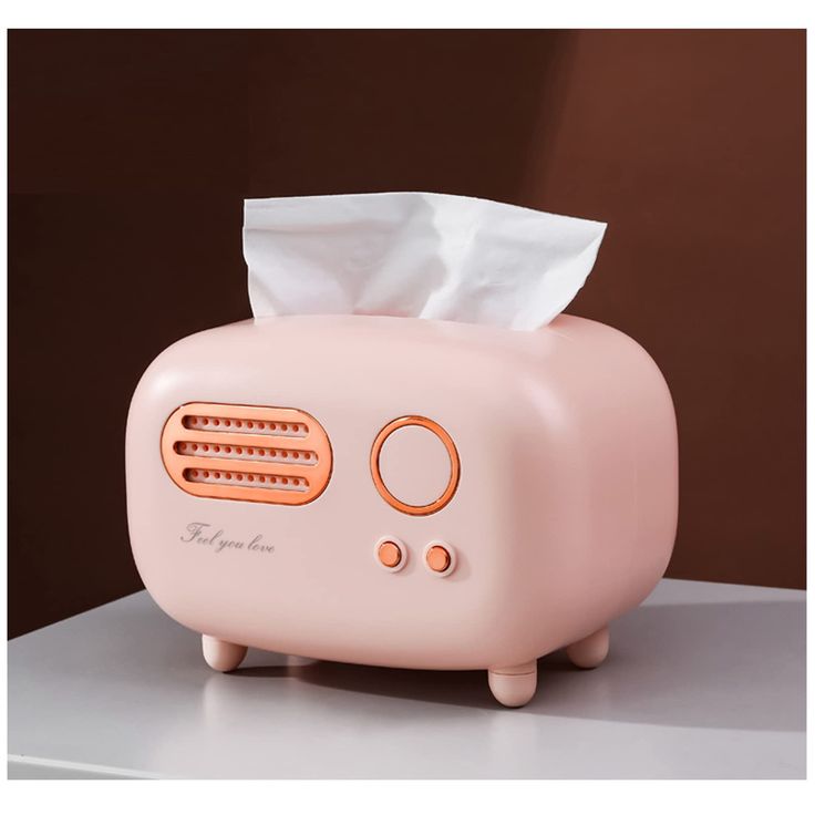 a pink toaster sitting on top of a counter with a tissue dispenser