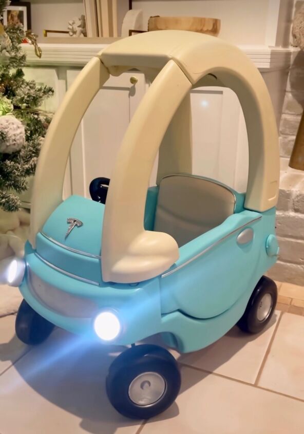 a blue and white toy car sitting on top of a tile floor