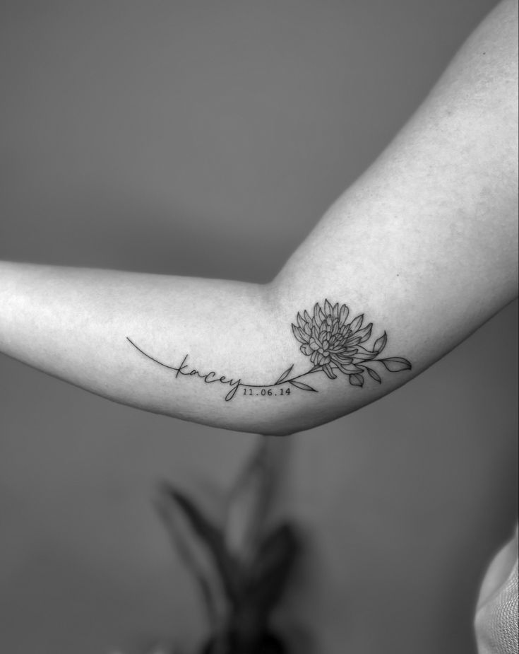 a woman's arm with a flower tattoo on it