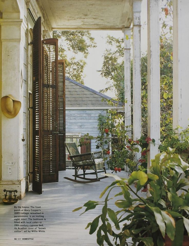 an outdoor porch with rocking chair and potted plants