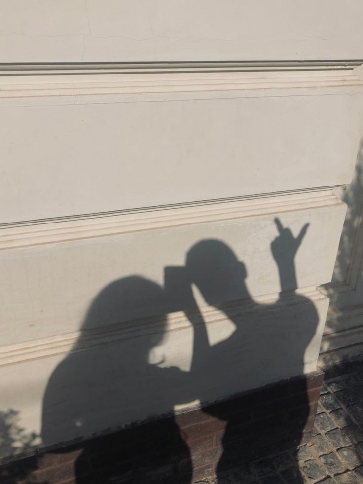 the shadow of a person standing in front of a garage door with their hand up