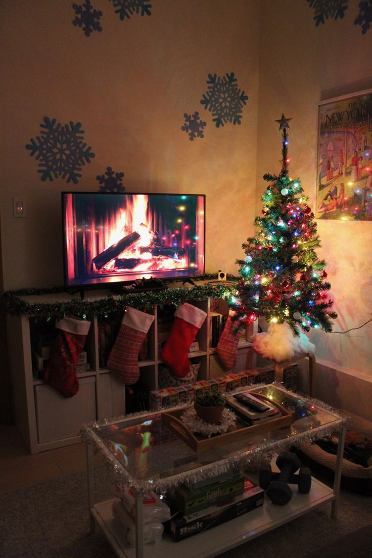 a living room with a christmas tree and television