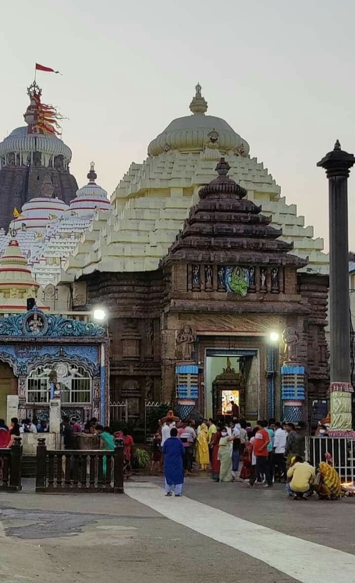 a group of people standing in front of a large building with many pillars and domes