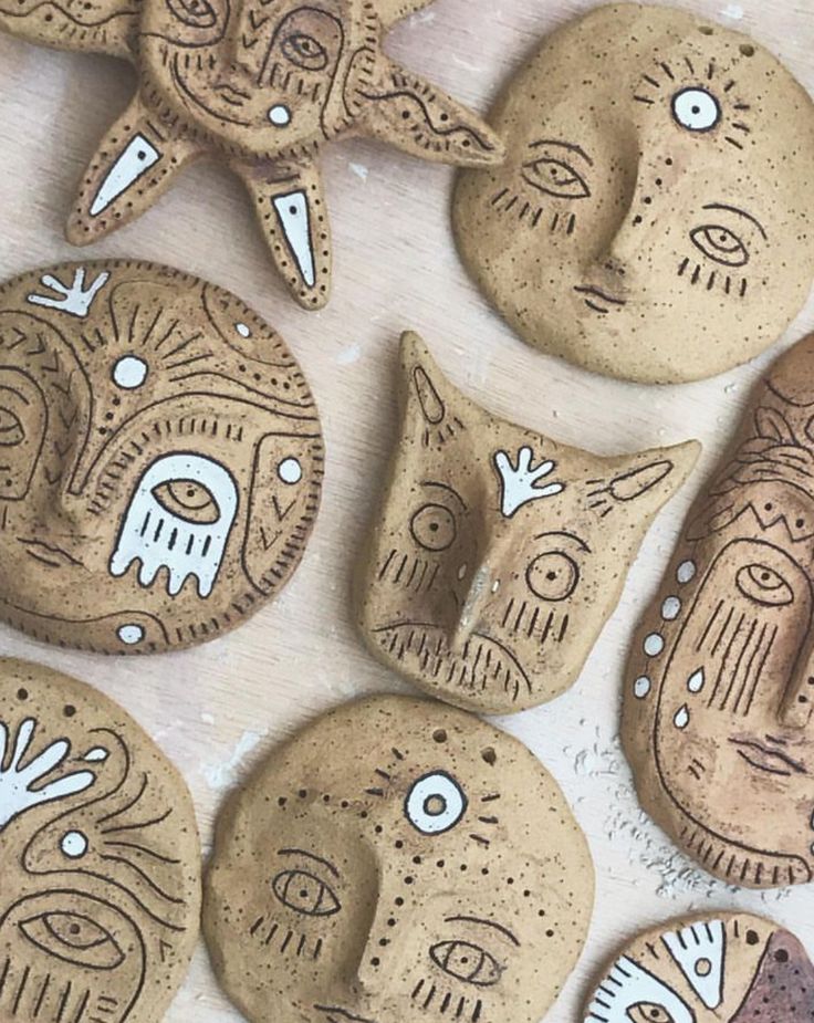 some cookies with faces on them sitting next to each other and one is made out of clay