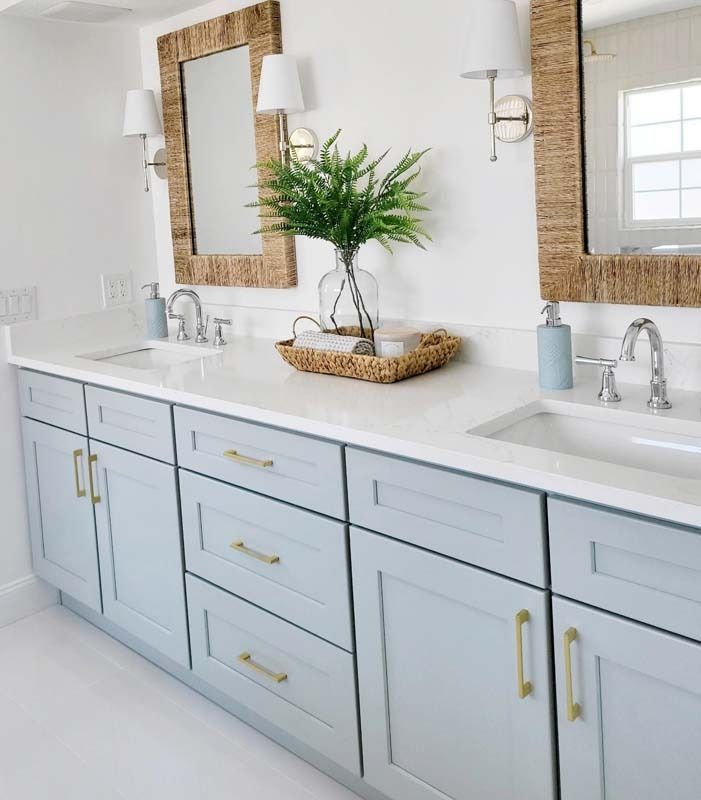 a bathroom with two sinks, mirrors and a plant in a basket on the counter