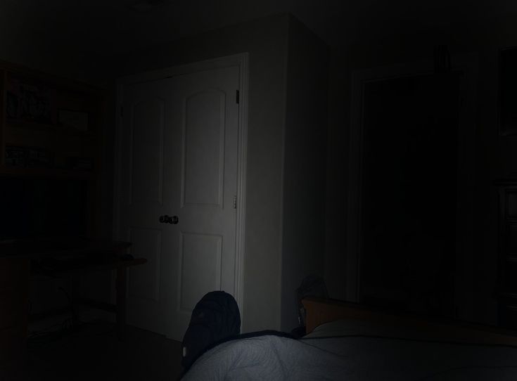 the person is laying down in the dark