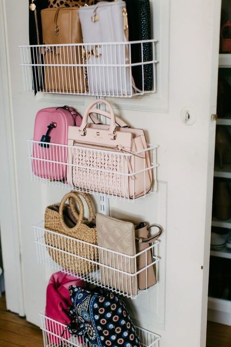 several purses and handbags are hanging on the wall next to a closet door