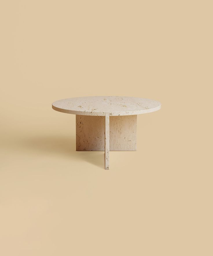 a round table with a white marble top on a tan background in the shape of a rectangle