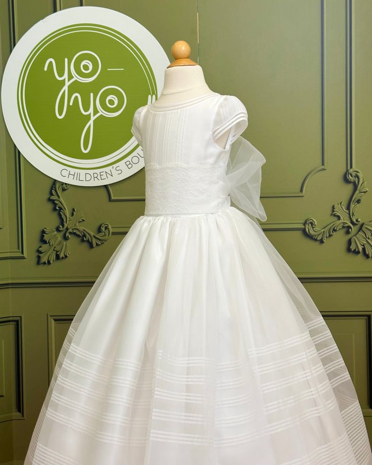 A traditional and classical first communion gown for girls, made with lightweight white organza. It has beautiful pleats throughout the body and skirt. The flower appliqué is removable. It has buttons on the back for closure. Made in Spain Dry clean Does not include crinoline 100% polyester Final Sale Fitted Dress With Pleated Bodice For First Communion, White First Communion Dress With Pleated Bodice, White Pleated Bodice Dress For First Communion, Classic Dresses With Fitted Bodice For First Communion, Fitted Tulle First Communion Dress For Confirmation, White Organza First Communion Dress With Ruffles, Confirmation Gown With Fitted Bodice And Tulle, Tulle Gown With Fitted Bodice For Confirmation, Fitted First Communion Dress