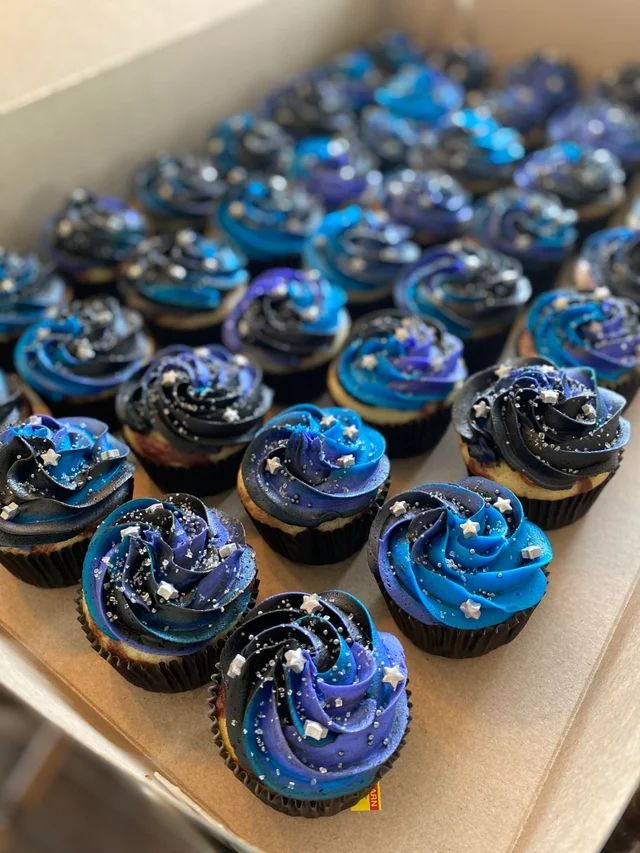 cupcakes with blue frosting in a box