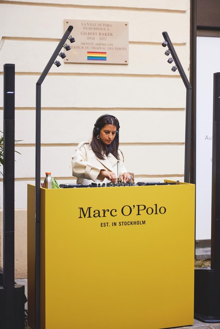 a woman standing behind a large yellow box