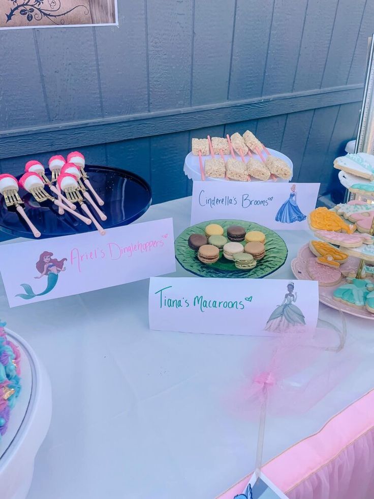 a table topped with lots of desserts and cupcakes on top of plates