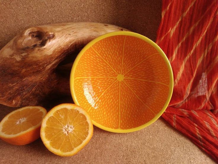 an orange sitting on top of a table next to slices of fruit