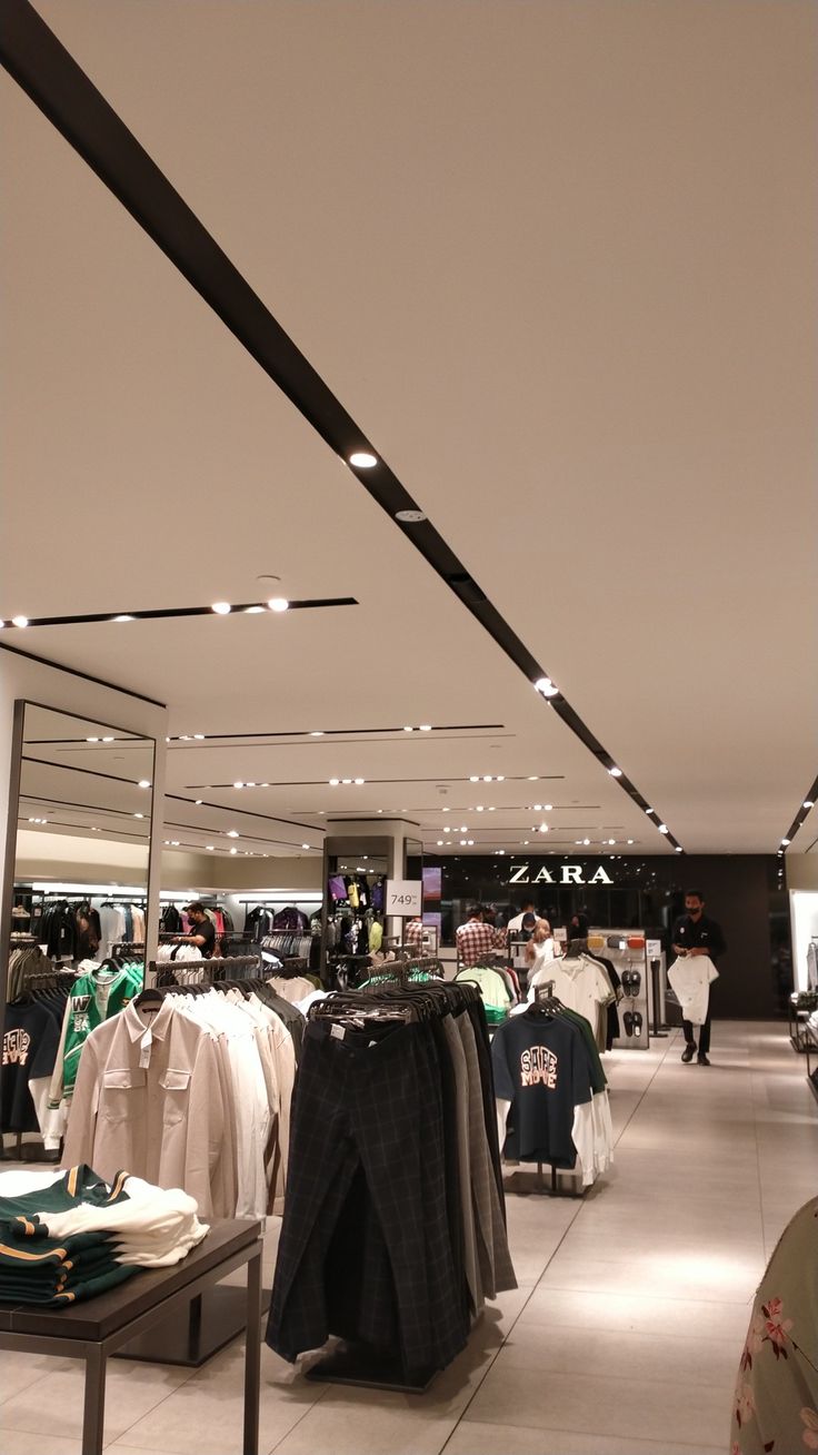 the inside of a clothing store with clothes on display