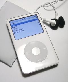 an ipod sitting on top of a table next to headphones