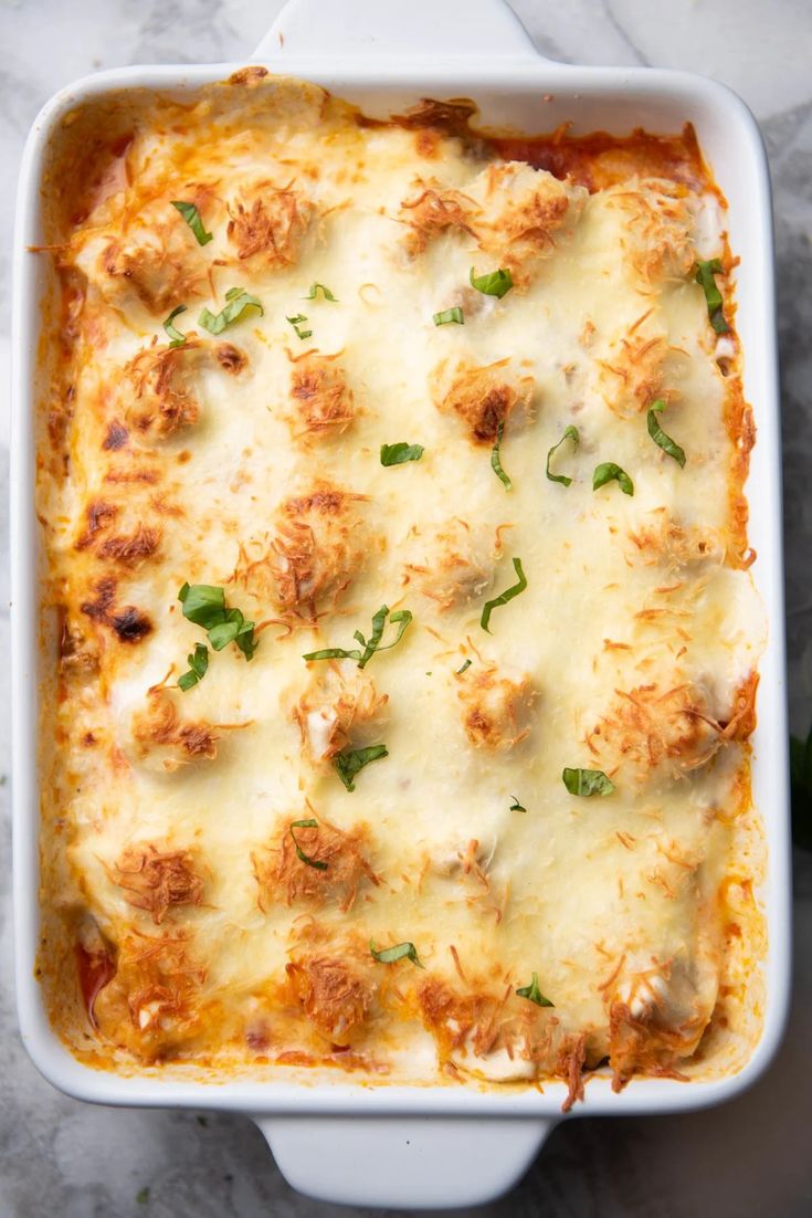 a casserole dish with meat and cheese in it on a marble countertop