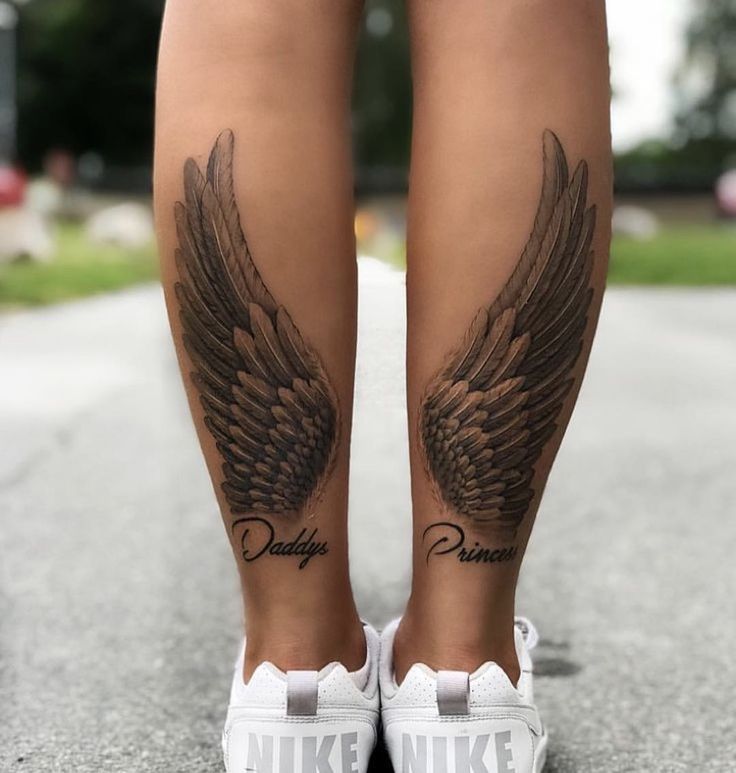 a woman's legs with tattoos and wings on her leg, both showing the word nike