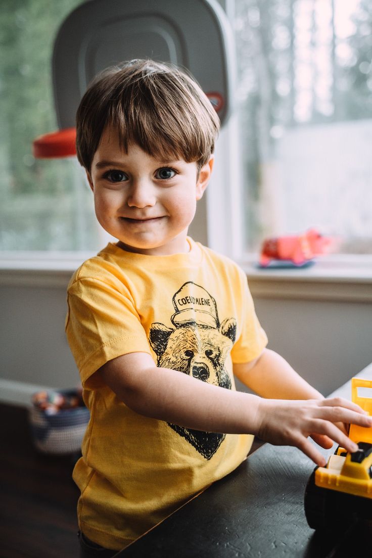 Unisex Sizing Mustard Yellow Coeur d'Alene Bear Design Relaxed Fit Crew Neck Top For Playtime, Casual Short Sleeve Tops For Playtime, Casual Crew Neck Shirt For Playtime, Casual Short Sleeve Shirt For Playtime, Short Sleeve Graphic Tee For Playtime, Graphic Tee Shirt For Playtime With Short Sleeves, Casual Yellow T-shirt For Playtime, Graphic Tee Short Sleeve Shirt For Playtime, Casual Yellow T-shirt For Play