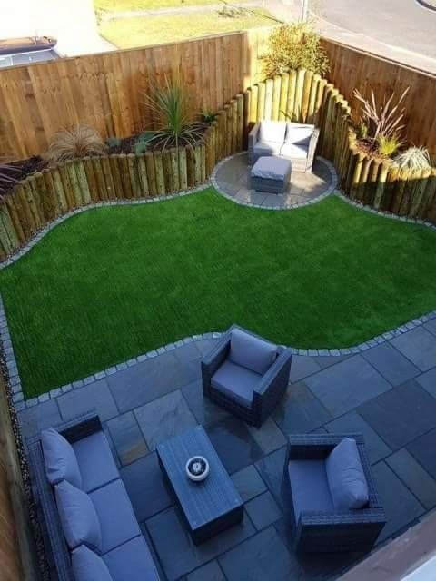 a small backyard with grass and seating area