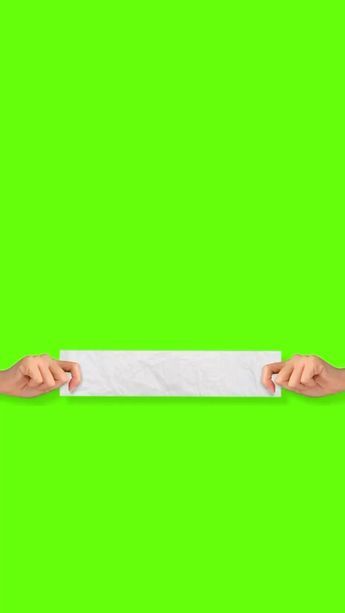 two hands holding a white paper against a green background